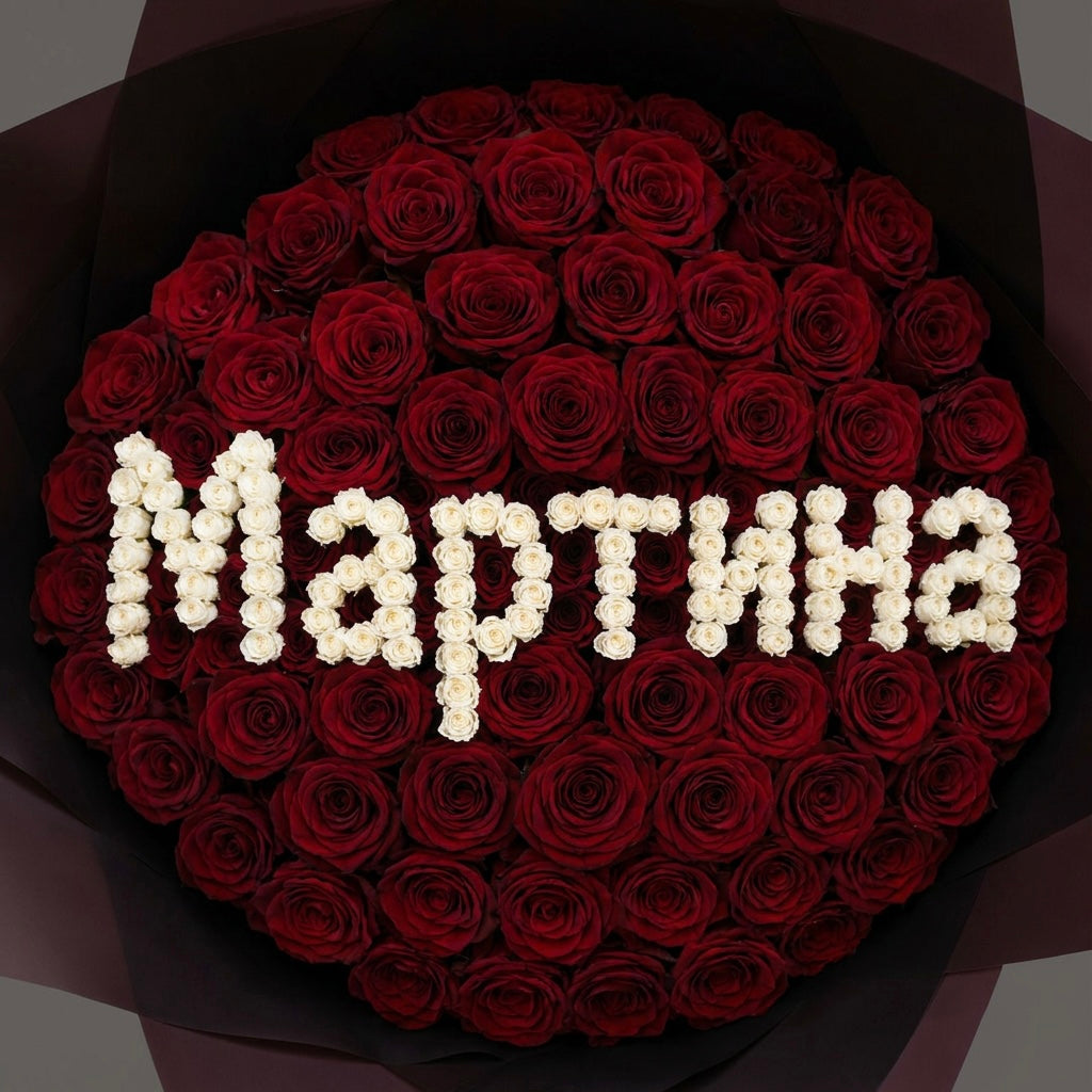 Bouquet of red roses with white letters spelling 'Marta' on a dark background
