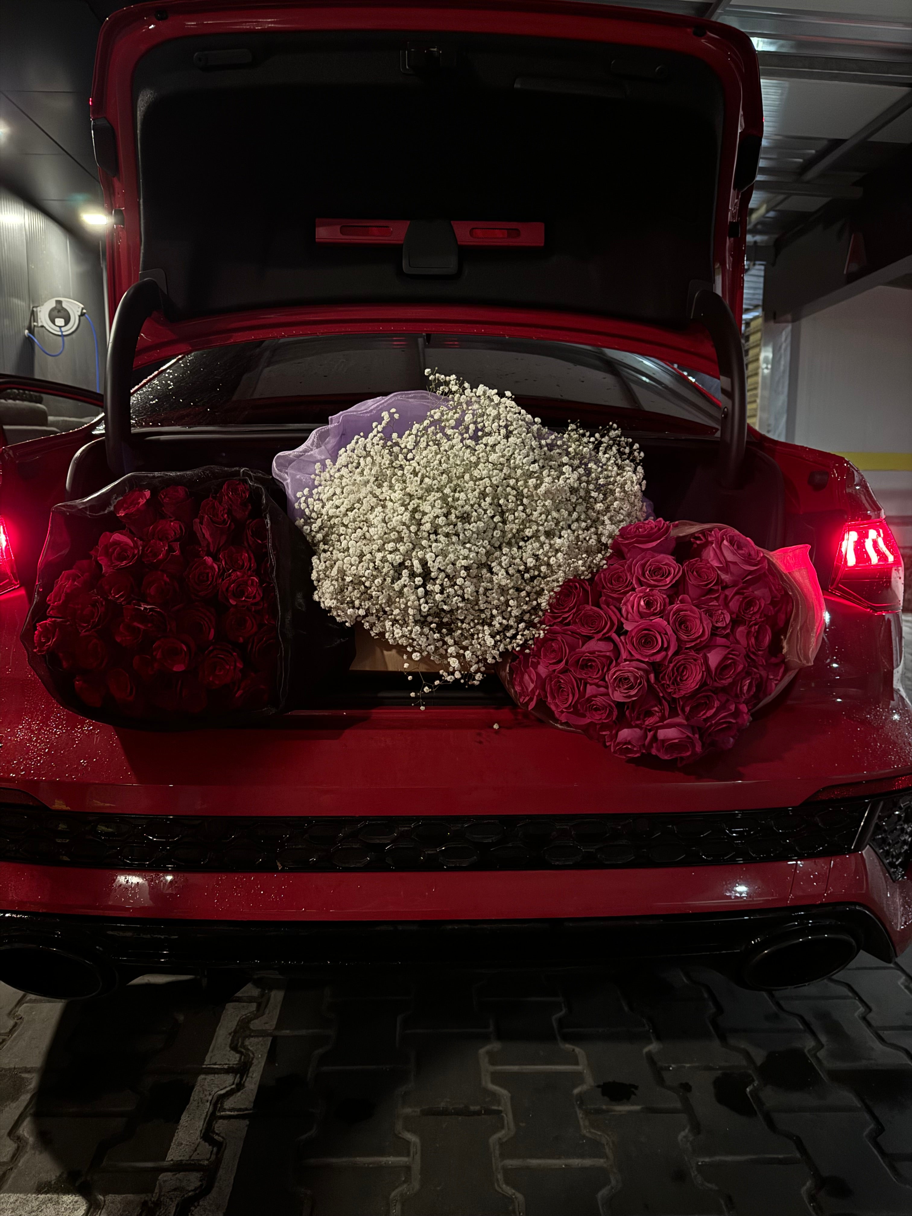 Red car with flowers in the trunk