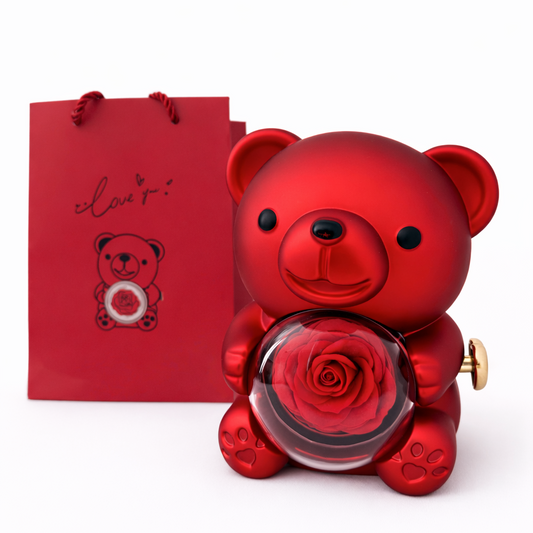 Red teddy bear-shaped perfume bottle with a rose and a matching red gift bag on a white background