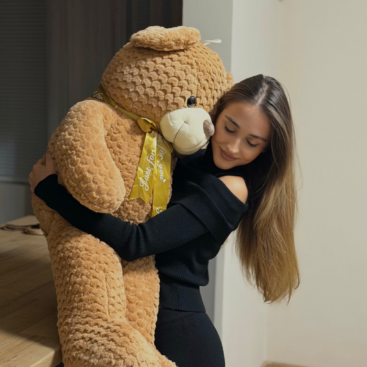 Woman holding a large teddy bear indoors